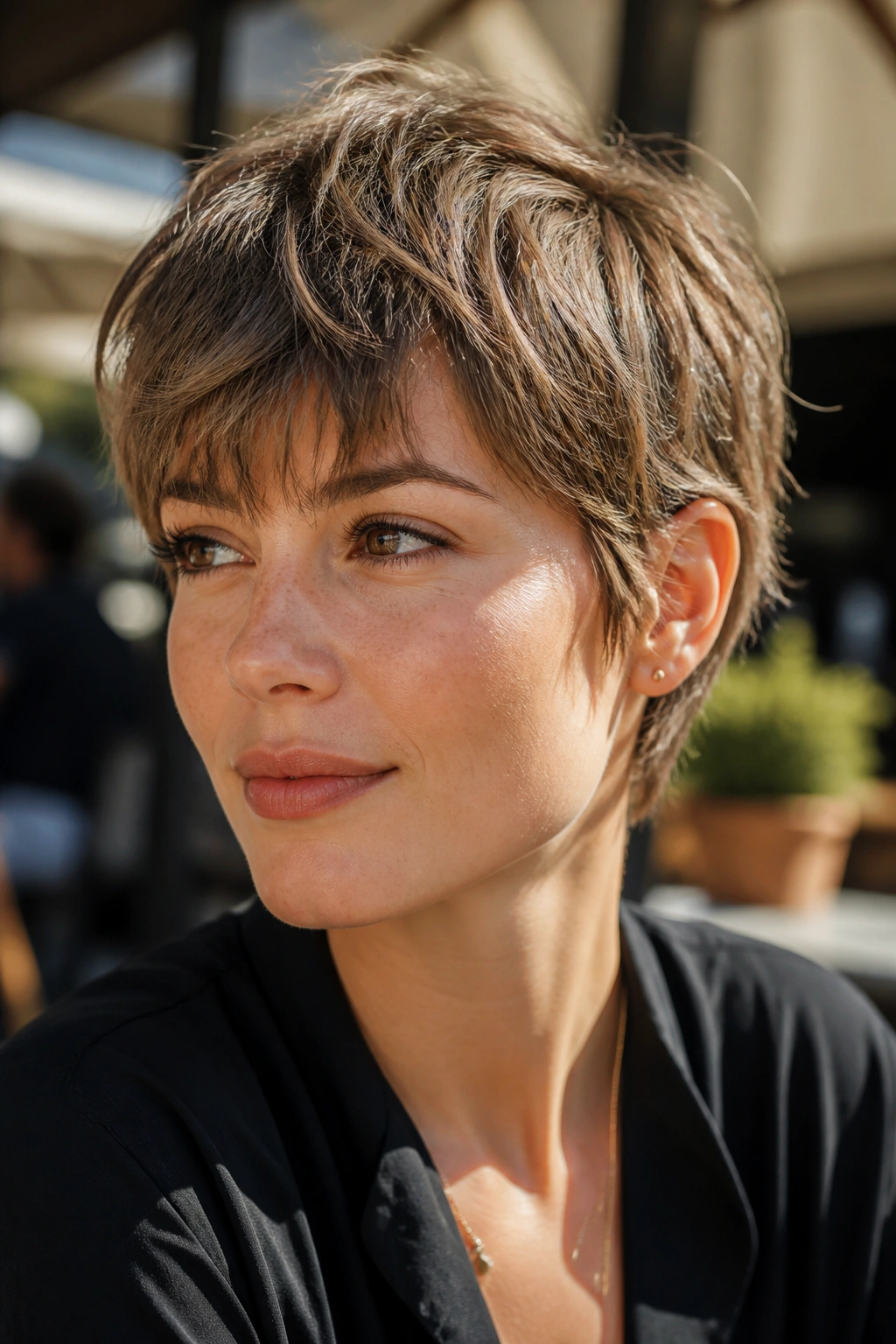 Portrait of a real woman with razor-cut shag pixie showing movement and broken edges