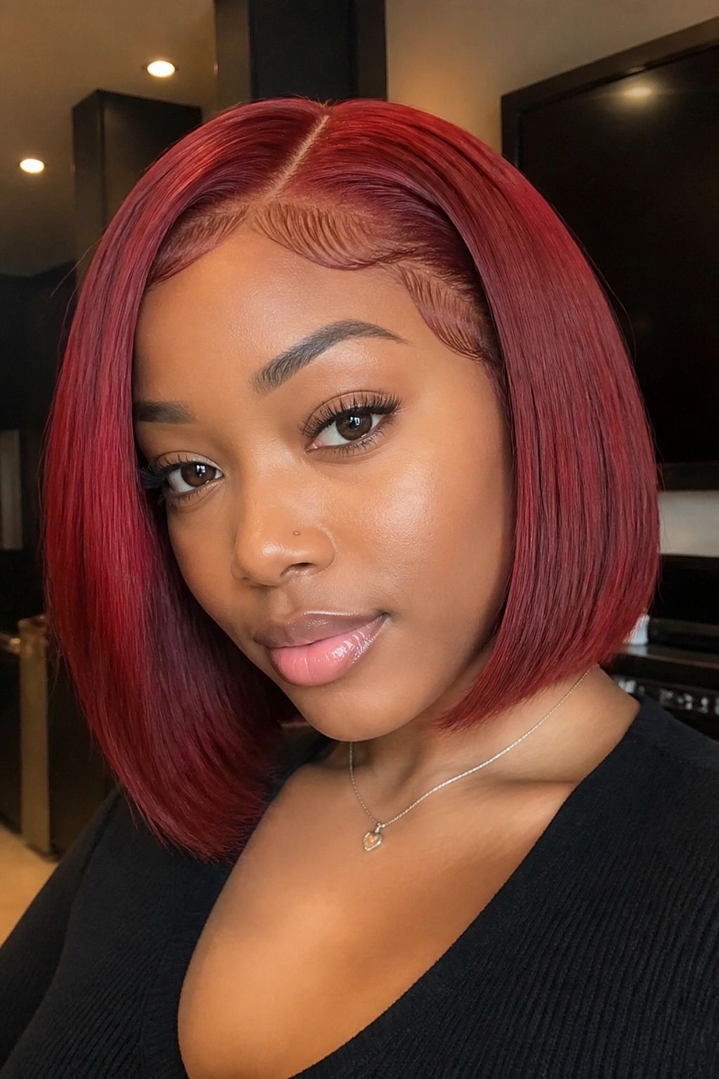 Close-up of a person with a red sew-in bob showing blunt ends.