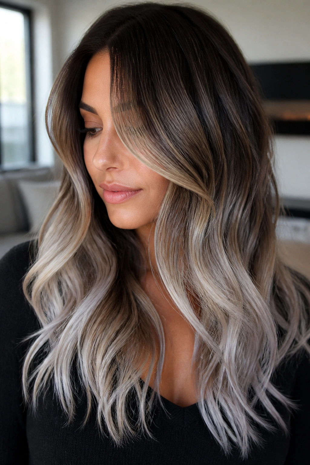 Close-up of brunette with reverse balayage featuring deep lowlights and icy ends in natural window light