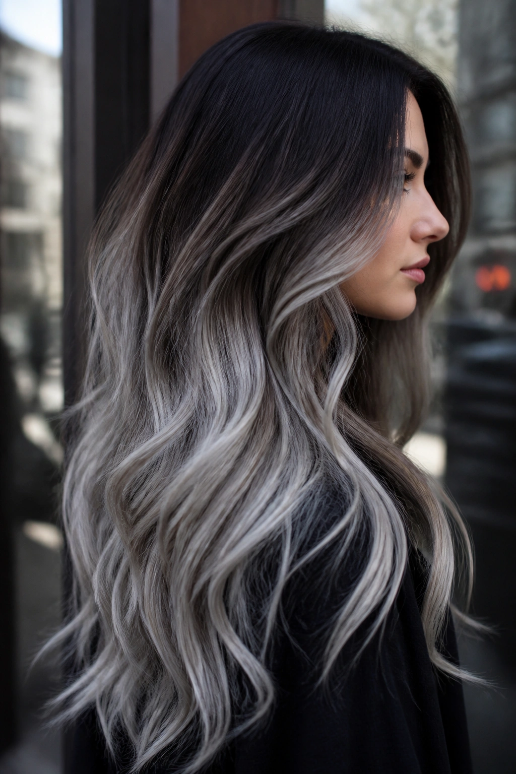 Side-profile of dark brunette with root-stretched silver smoke