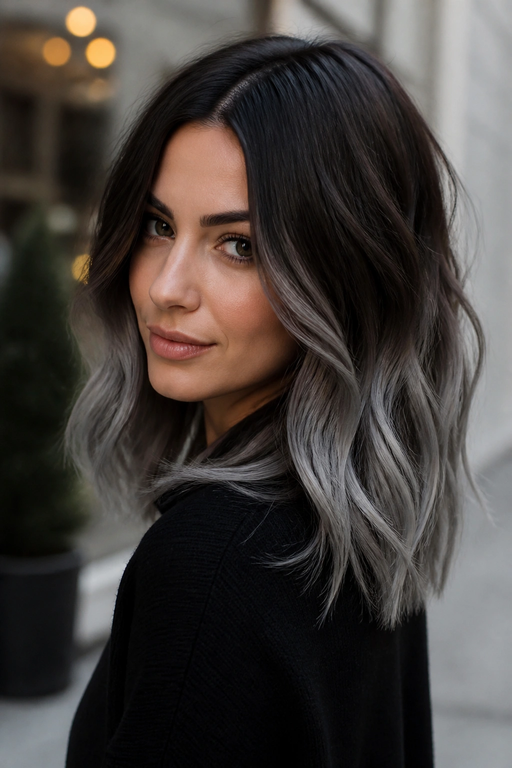 Close-up portrait of a real woman with rooted grey ombré on brown hair