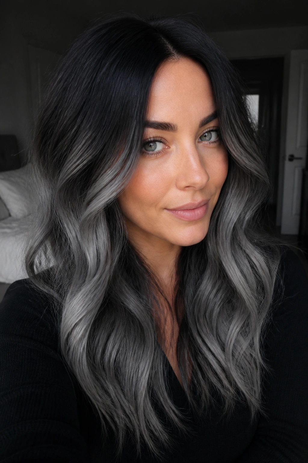 Portrait of a person with black roots fading to smoky gray.