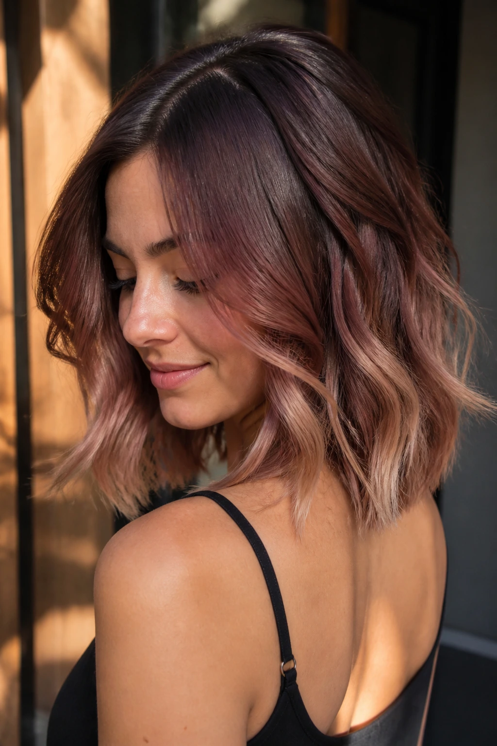 Close-up portrait of a woman with rosewood balayage and blonde ends on a brown bob