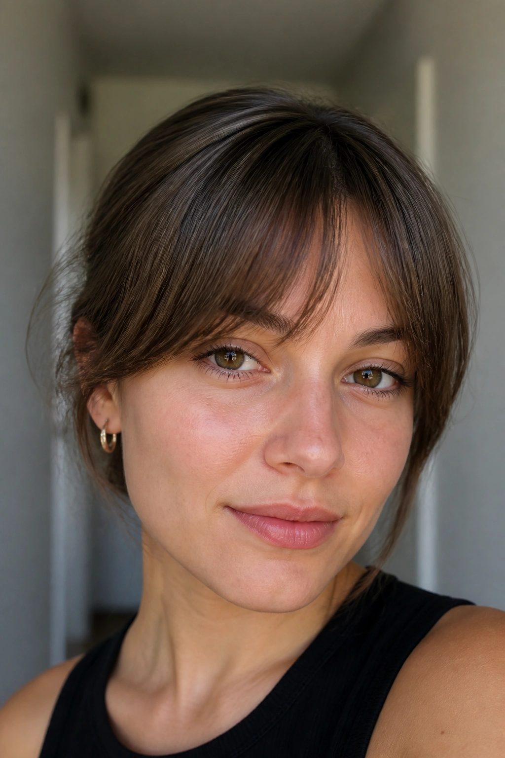 Close-up of a real woman with rounded arch bangs in soft daylight