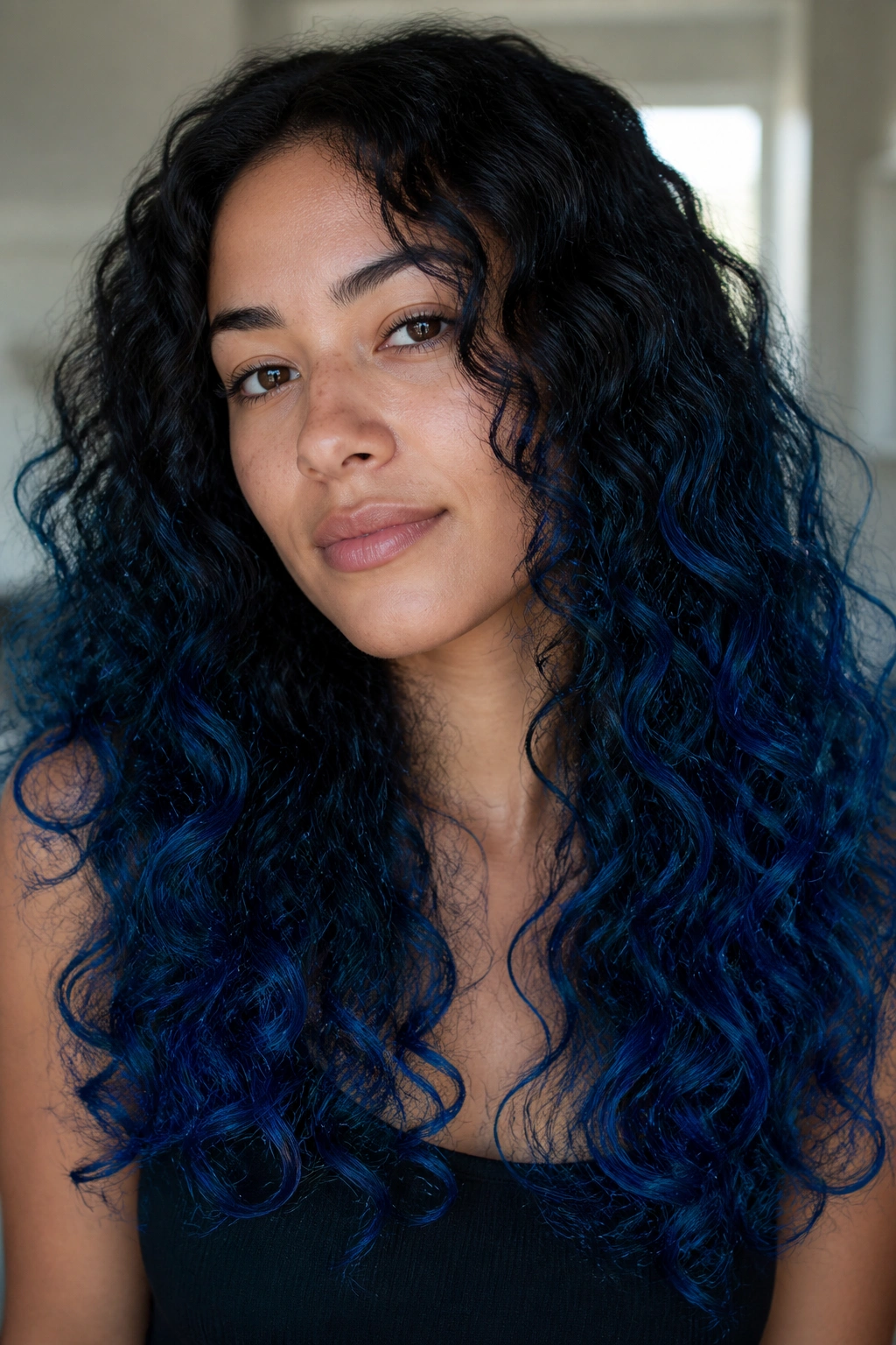 Close-up of real person with royal blue ombre on curly long hair