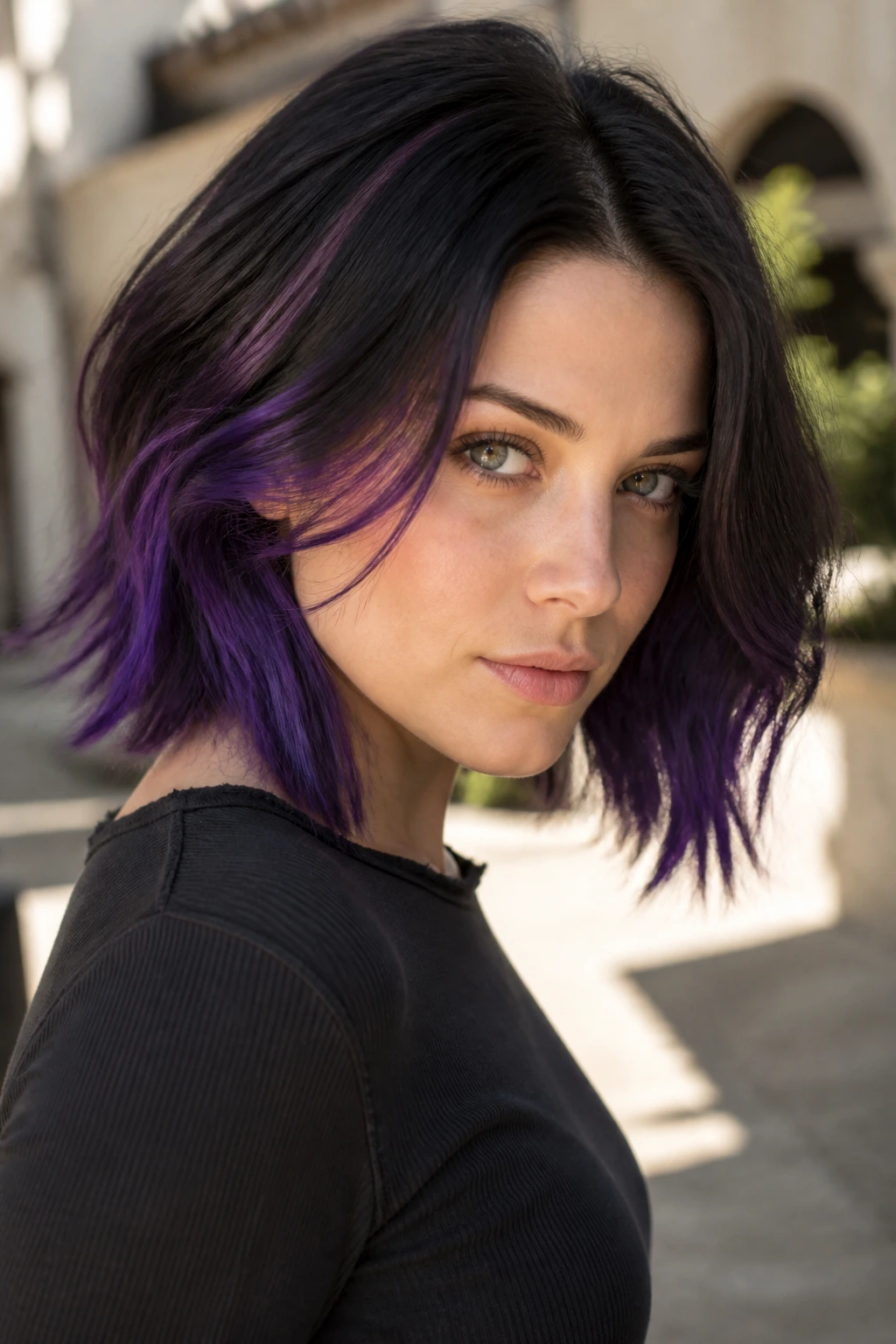 Close-up of a real person showing royal purple streaks in hair against a sunlit outdoor background.