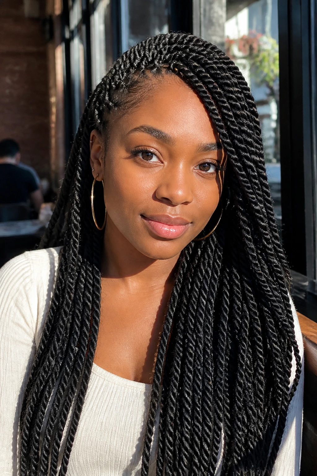 Close-up of a real woman with long Senegalese twists under cafe light