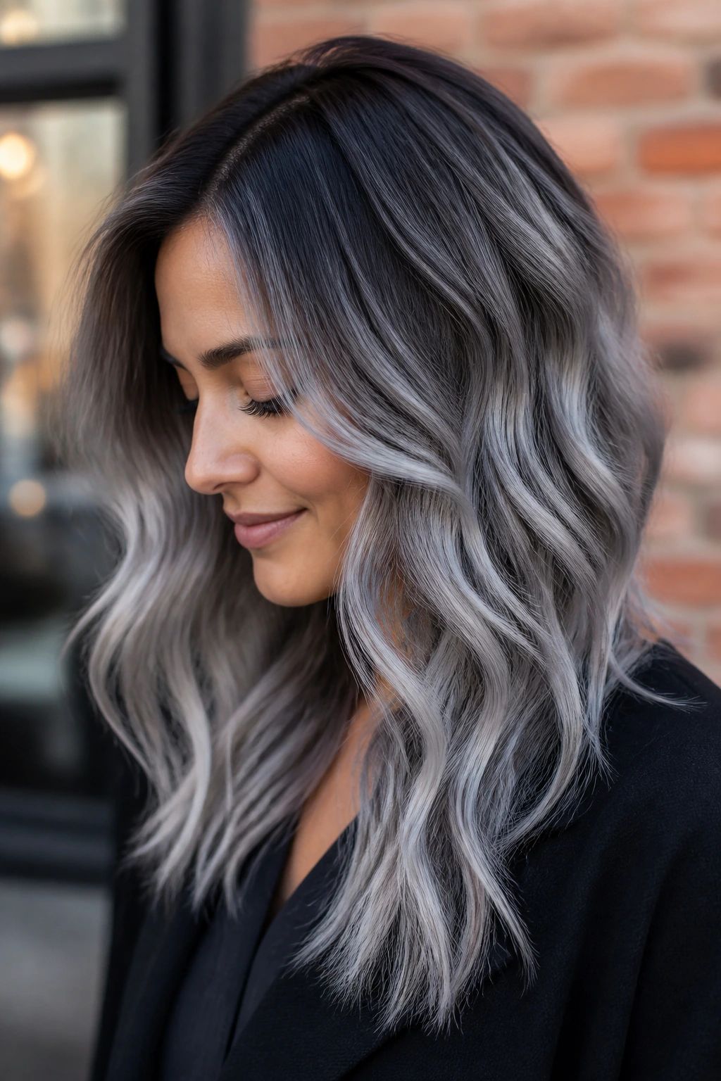 Close-up of a real woman with a shadow-root silver fade on brown hair