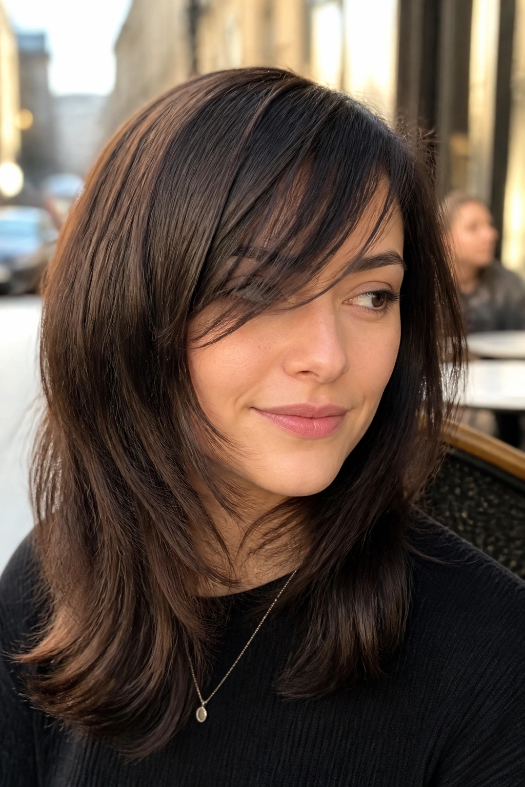 Close-up portrait of a real woman with side-swept razor bangs.