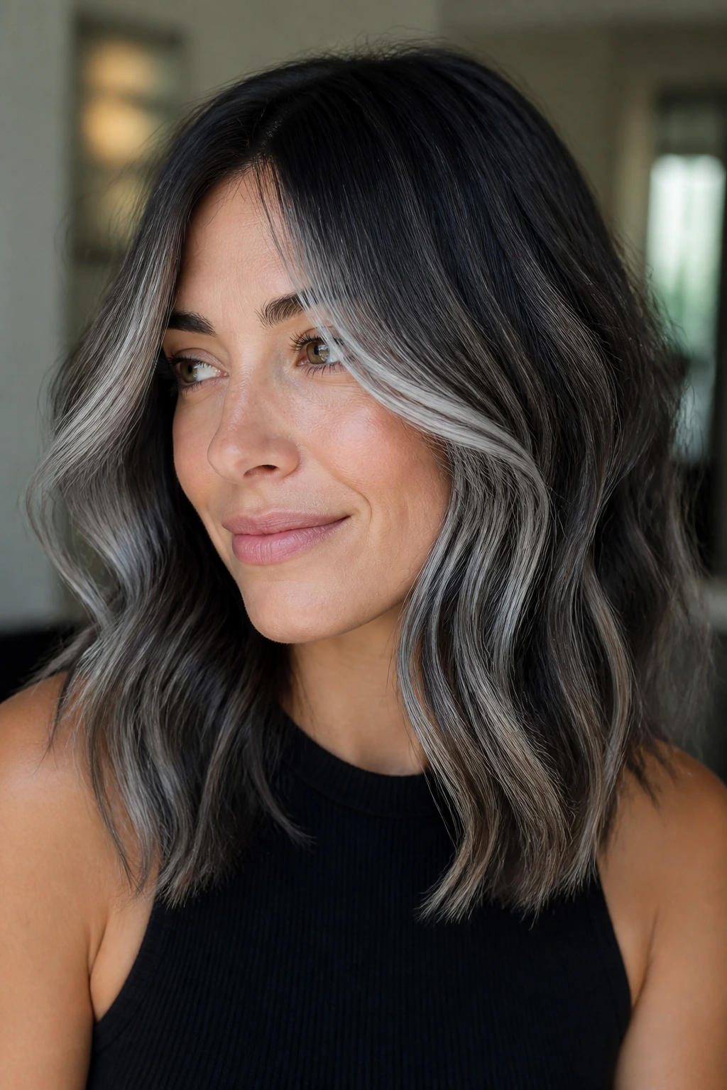 Close-up of a woman with dark brunette hair featuring silver balayage framing the face