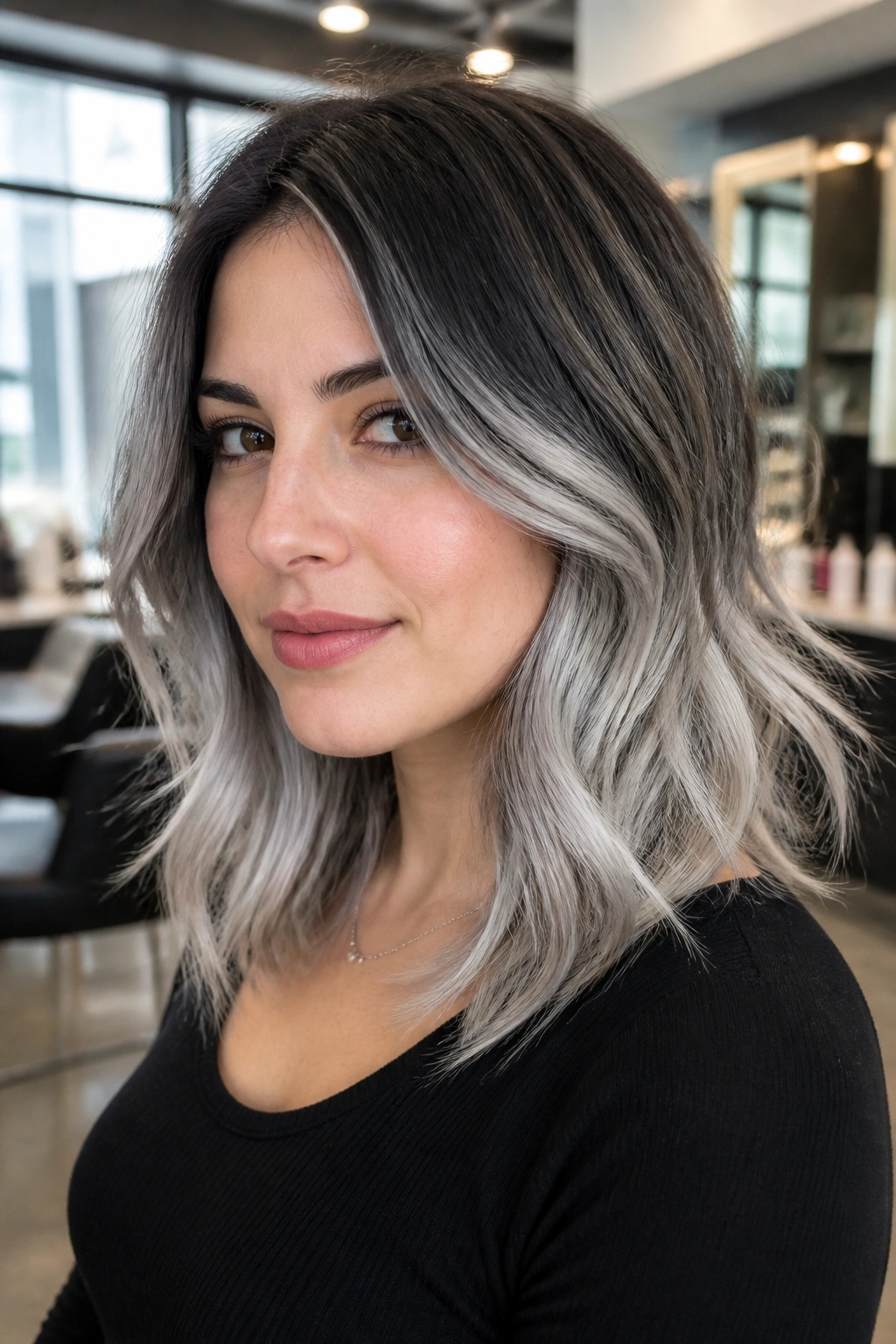 Close-up of a real person with silver balayage on layered midi cut.