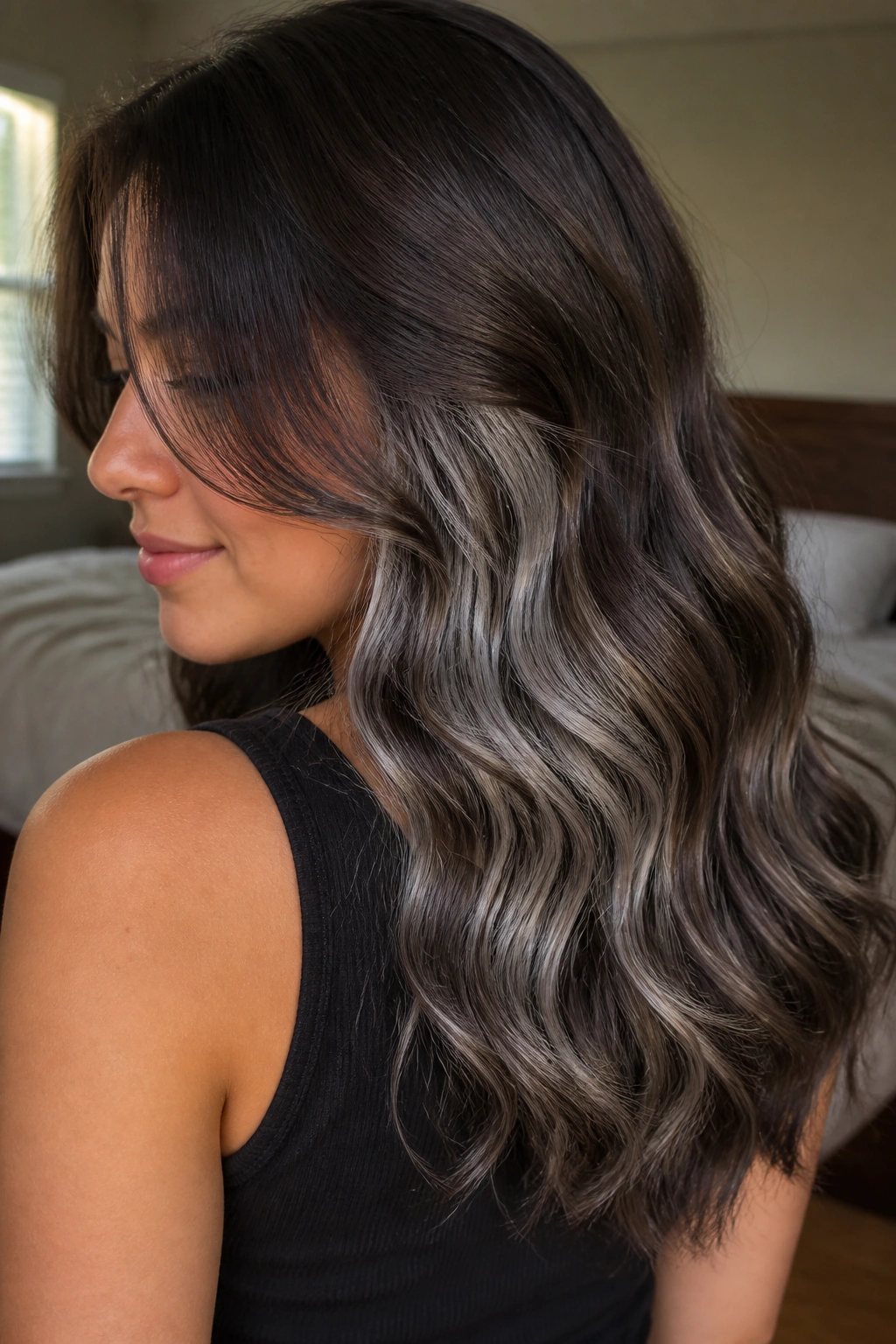 Close-up portrait of a real woman with wavy brown hair showing hidden silver peekaboo layers