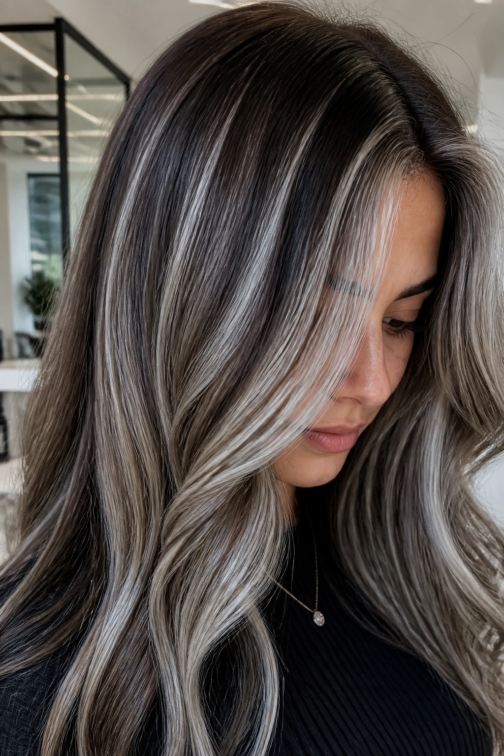 Close-up of silver-platinum ribbons woven through brown hair