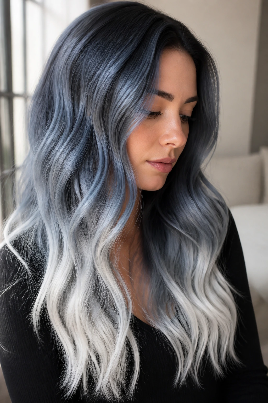 Close-up portrait of a real woman with muted slate blue to white ombre on long wavy hair.