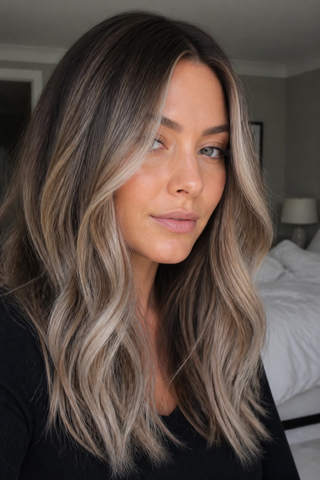 Close-up portrait of a real woman with smoky beige balayage and cool ash glaze.