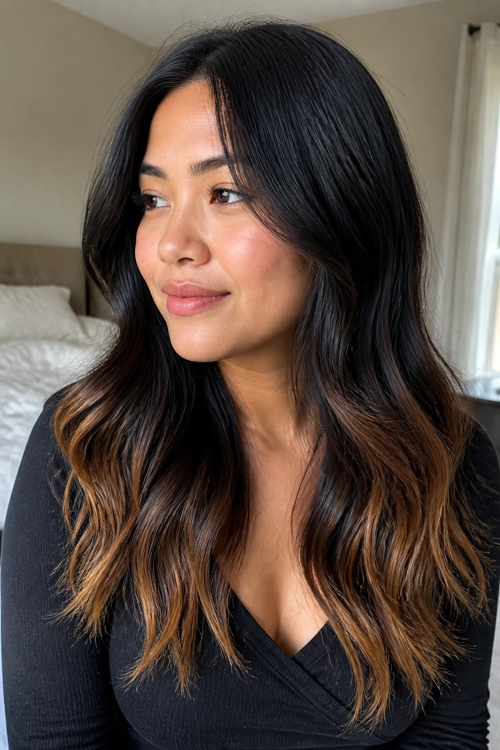 Close-up of real woman with smoky black hair and toasted caramel ends on a round face