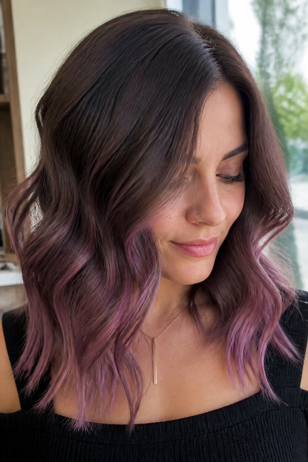 Portrait of a real woman with smoky chocolate hair and orchid balayage in soft waves