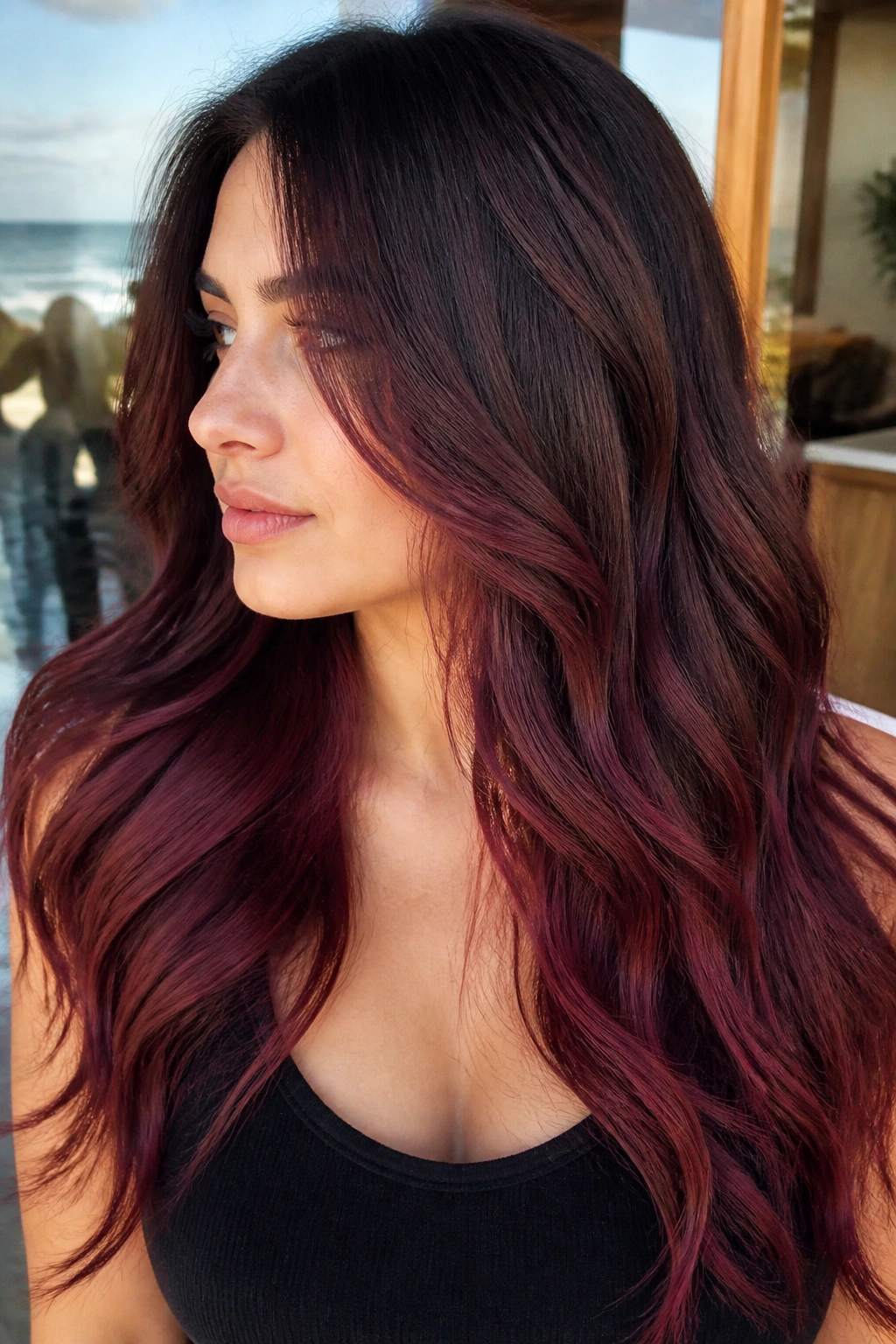Close-up portrait of a real woman with smoky cranberry ombré on brunette hair