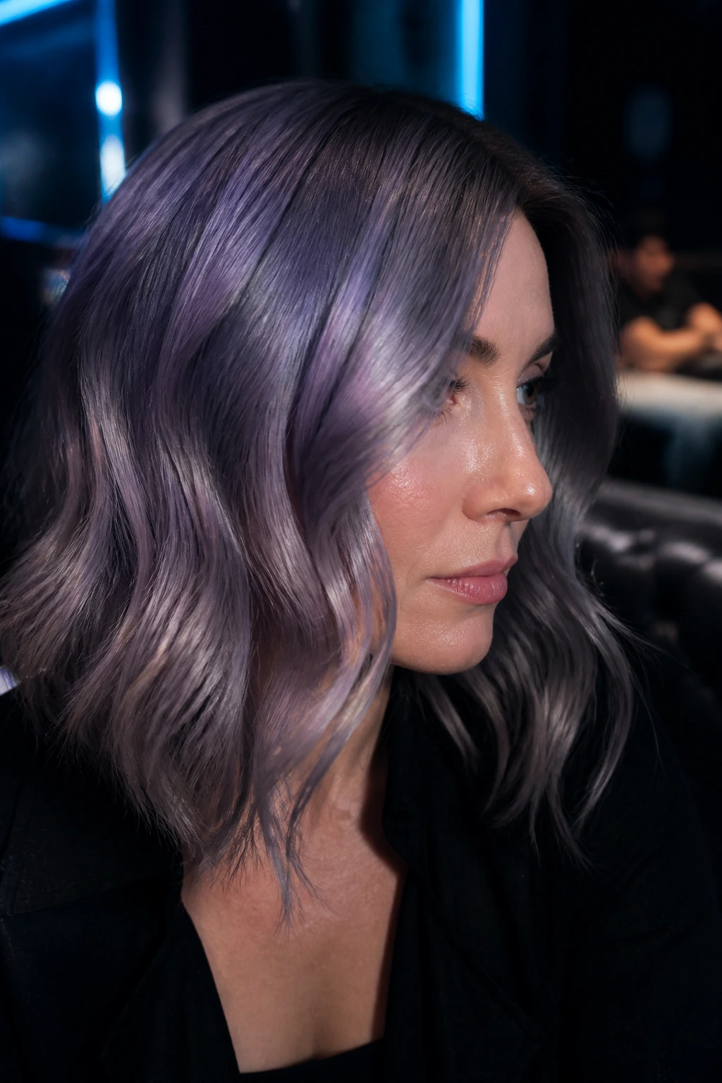 Close-up portrait of a real woman with smoky iridescent grey hair showing violet sheen