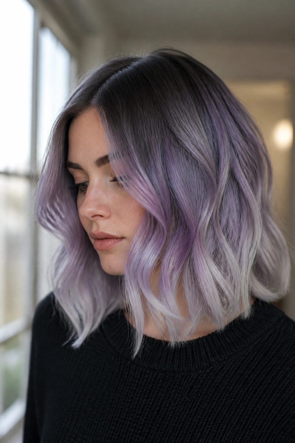 Close-up portrait of smoky lavender melt hair on a real person with ash roots, lavender mid-lengths, and silver ends in soft light