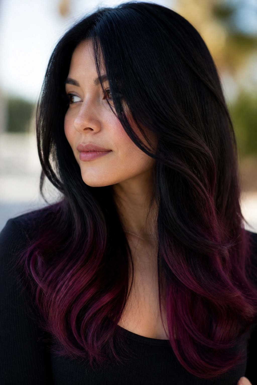 Close-up of long black hair with smoky plum ends on a real person