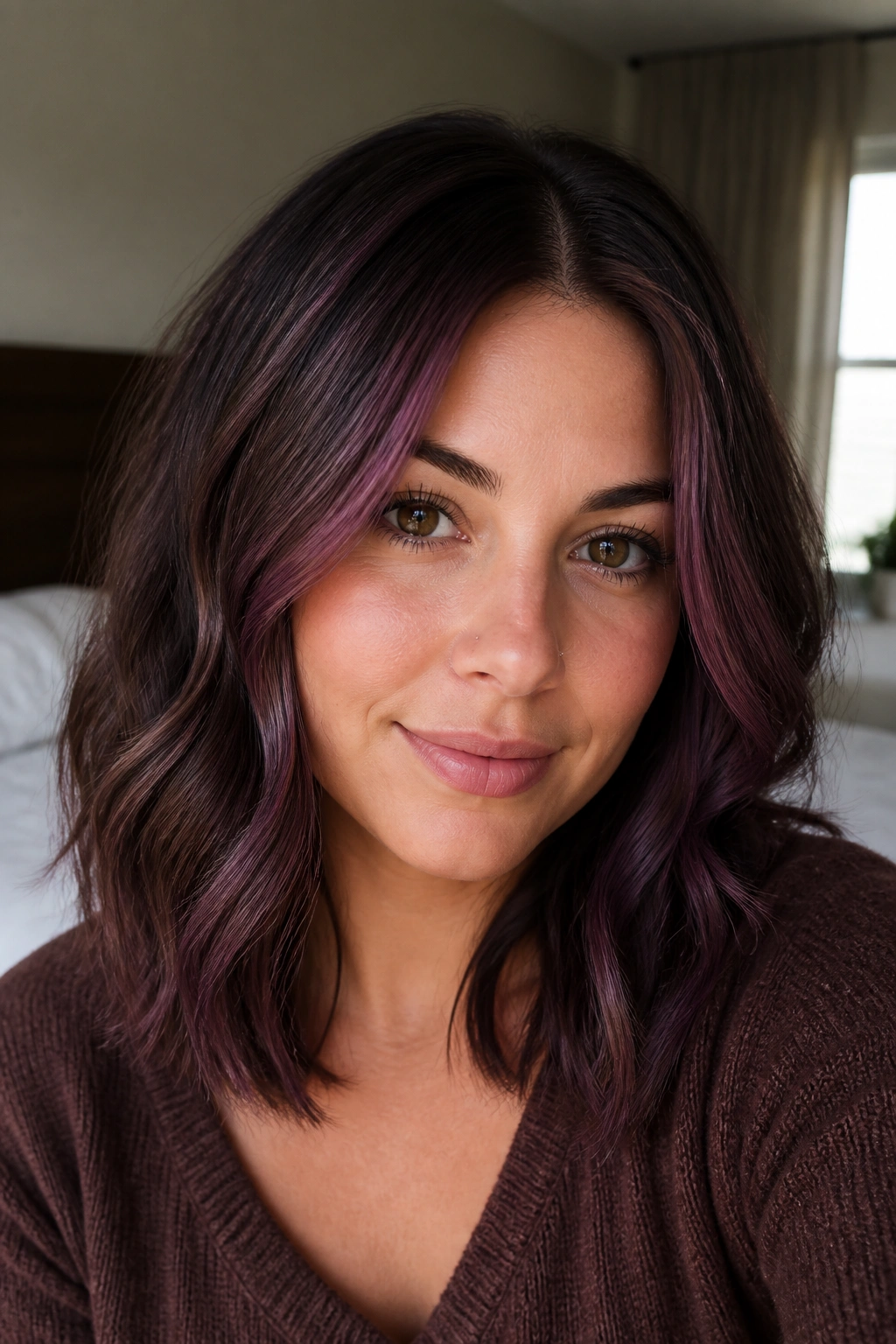 Close-up of a real woman's hair with smoky plum ribbons through chocolate brown.