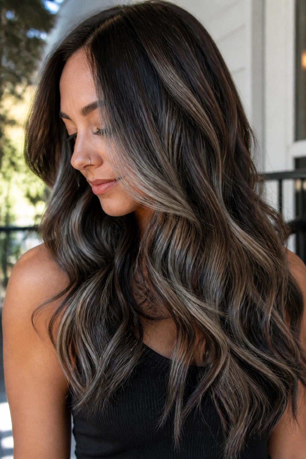 Real woman with long wavy hair showing smoky grey ribbon highlights