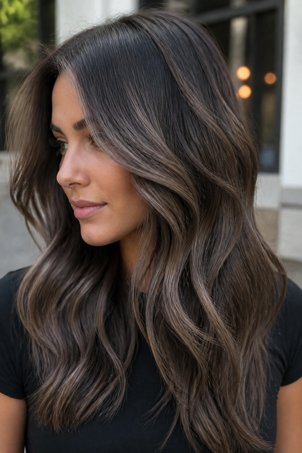 Cool-toned brunette with smoky taupe highlights under daylight.
