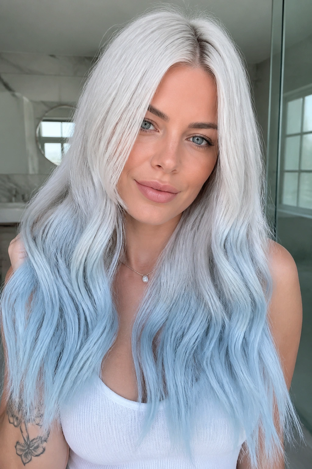 Close-up of a real woman with pearl white to pale blue arctic fade on long hair.