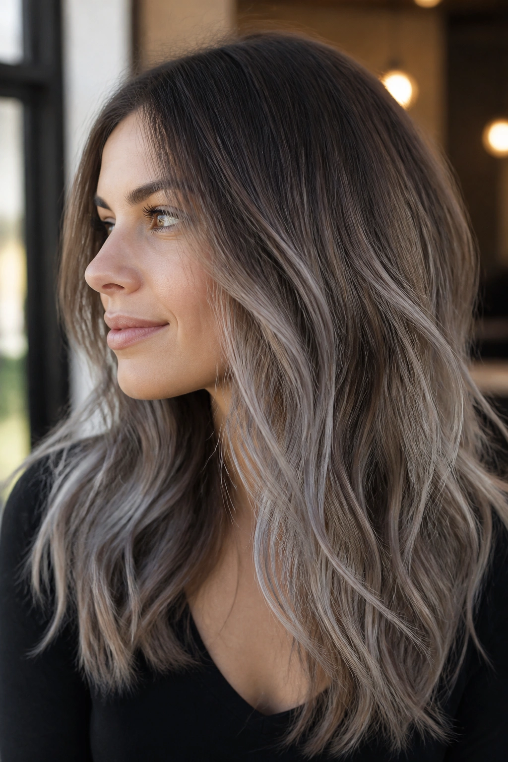 Portrait of a real woman with fine brown hair showing soft ash-gray balayage wisps
