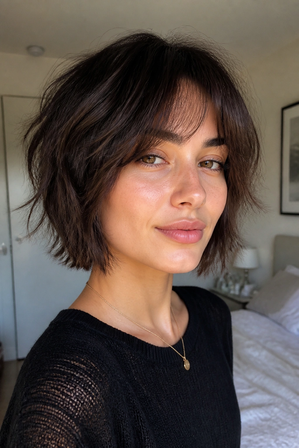 Close-up of a real woman with chin-length shag and curtain fringe, natural window light