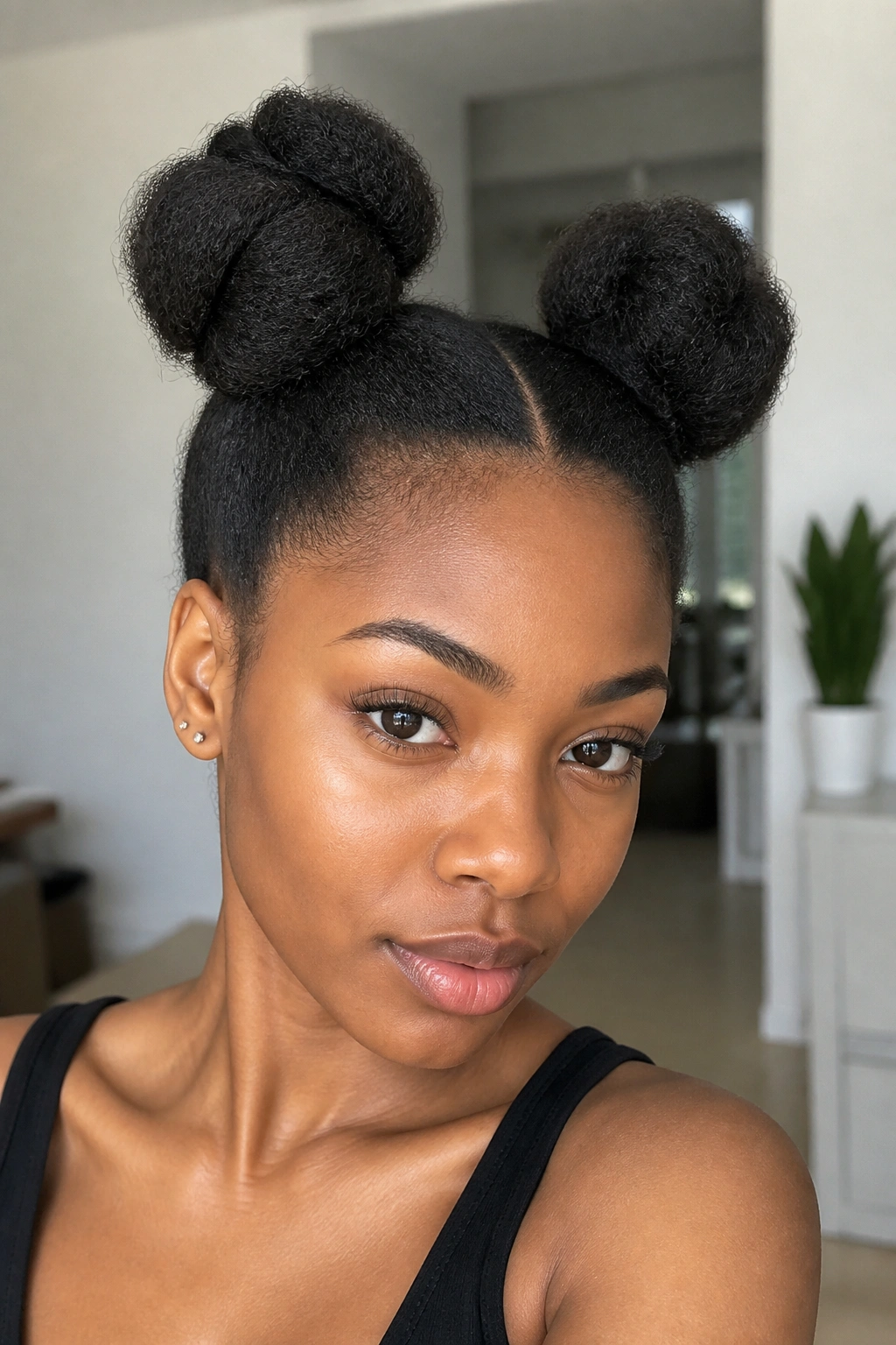 Real person with space buns on stretched hair in a bright room