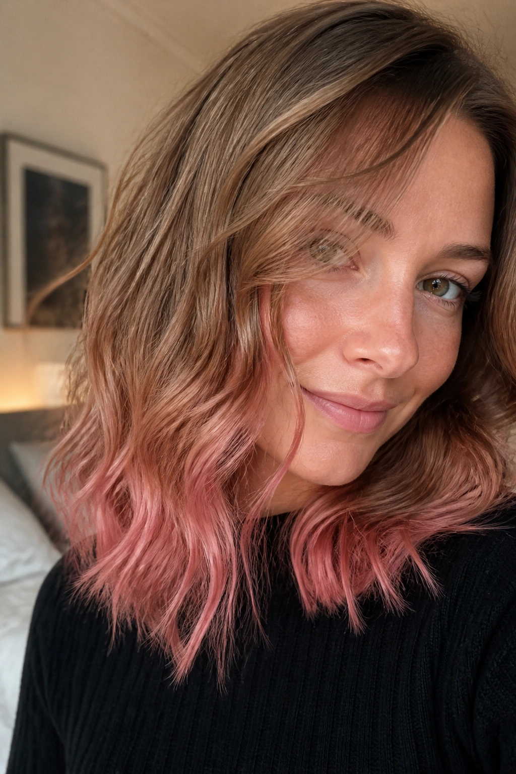 Close-up of strawberry-pink ends on light brown hair with soft waves