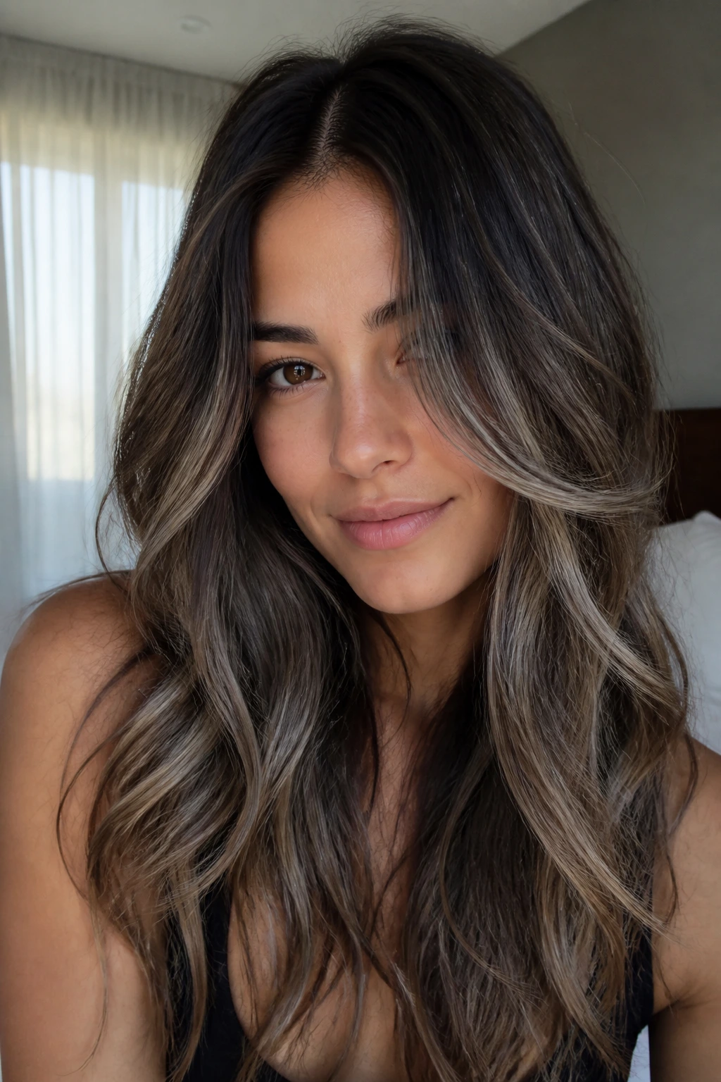Close-up of a real woman with subtle ash balayage on dark brown hair