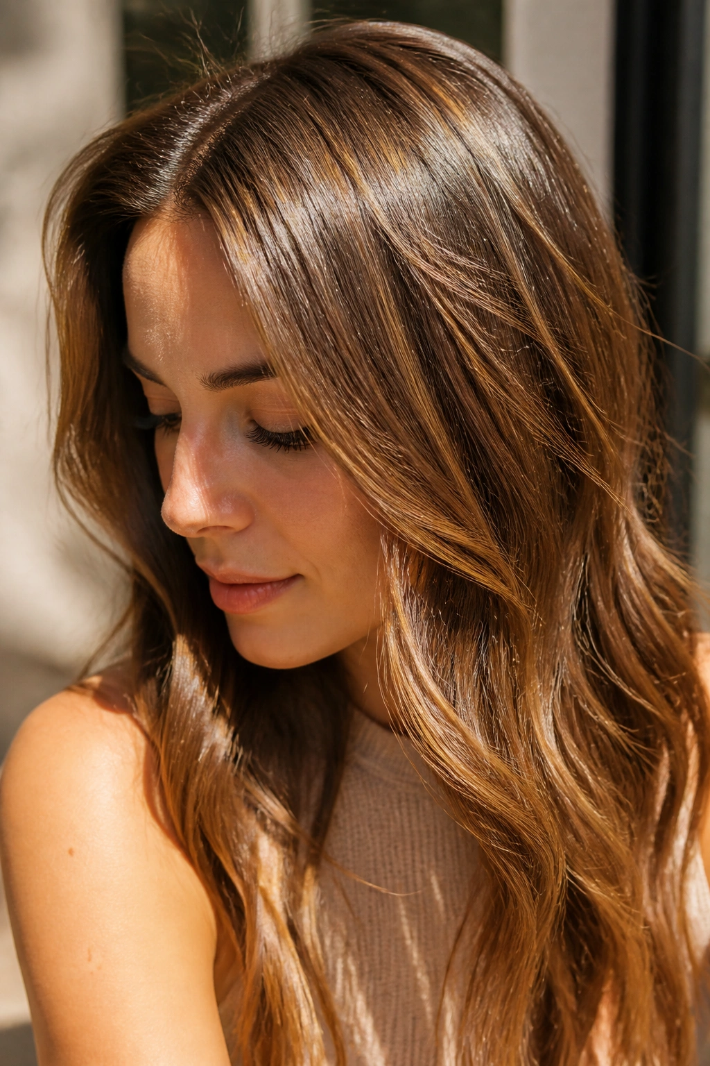 Close-up of brown hair with sunlit babylights giving a barely-there lift on a real person.
