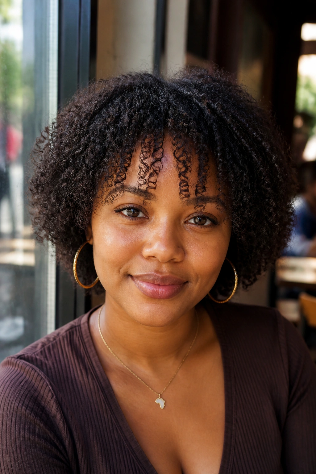 Close-up of a person with tapered coily bangs that keep the face open