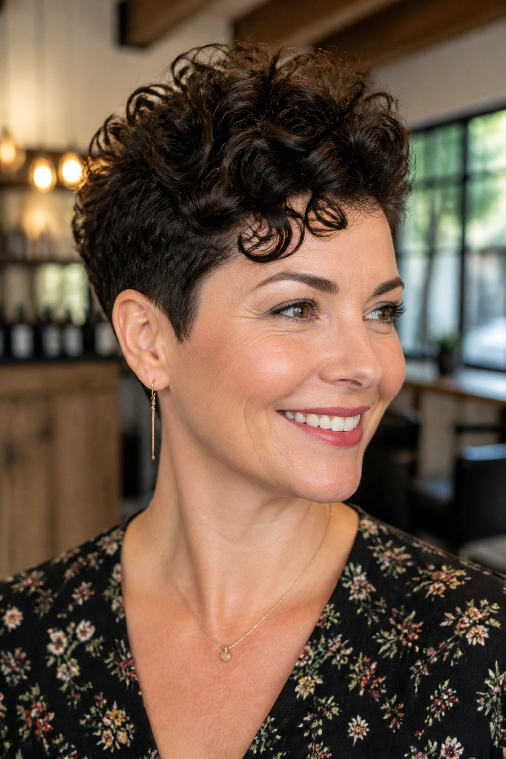 Close-up of a real woman with a tapered curly pixie and crown lift, curls lifted at crown