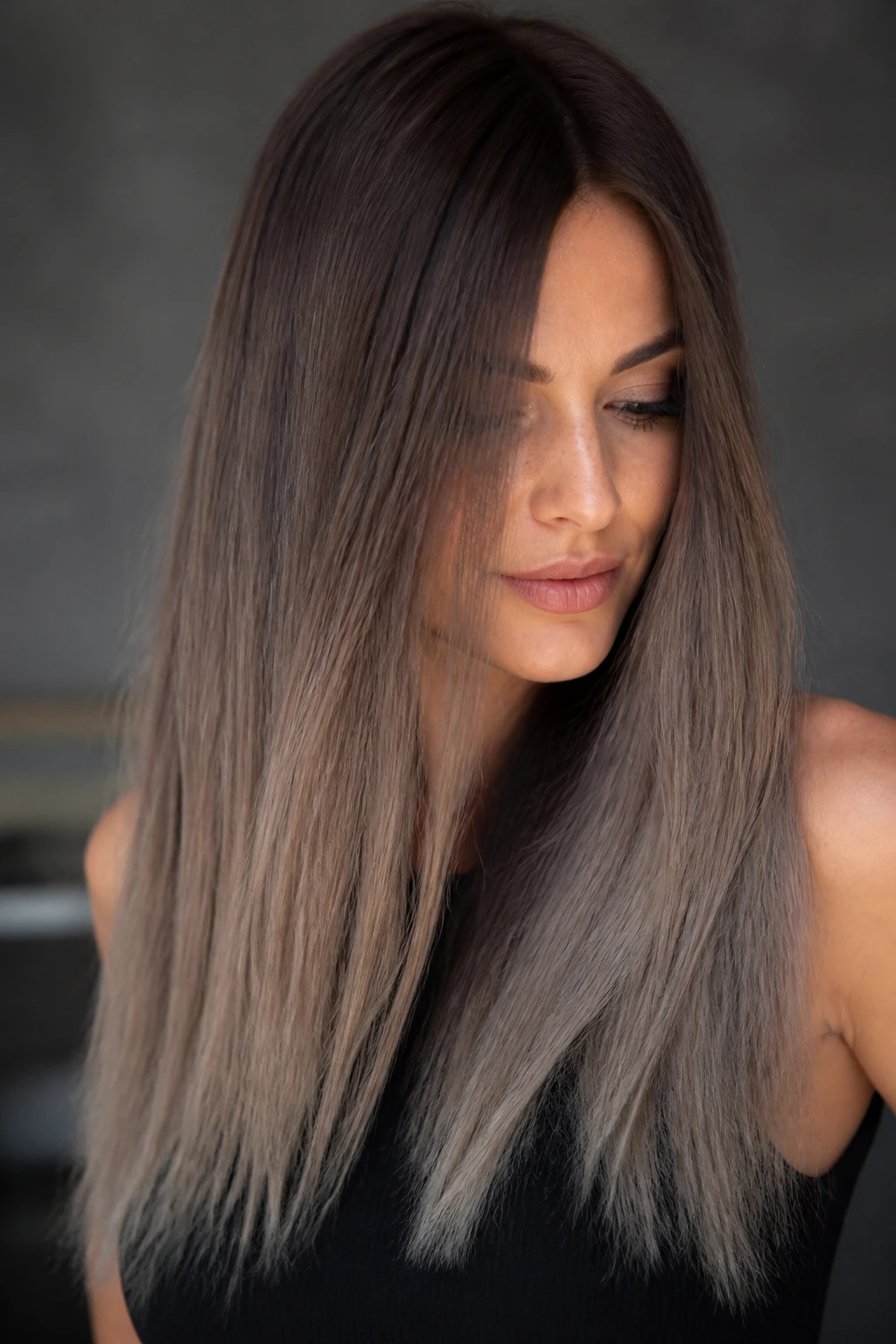 Portrait of a real woman with taupe brown to mushroom melt gradient in long hair