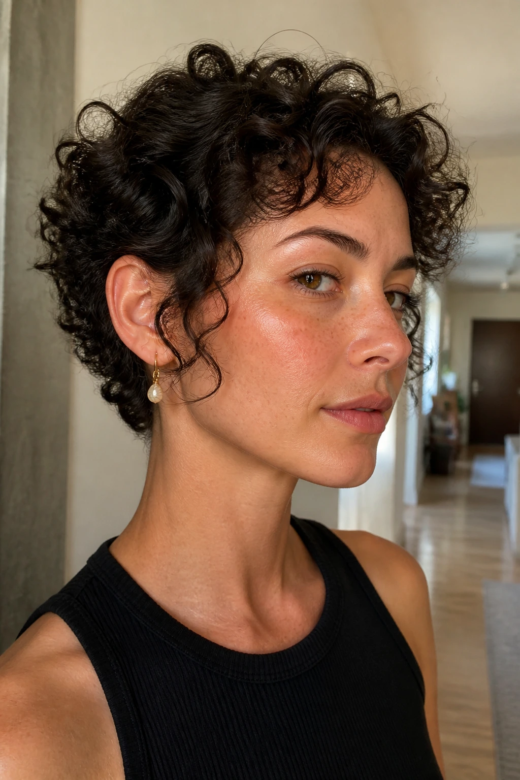 Close-up of a person with temple-length curls in apartment hallway light