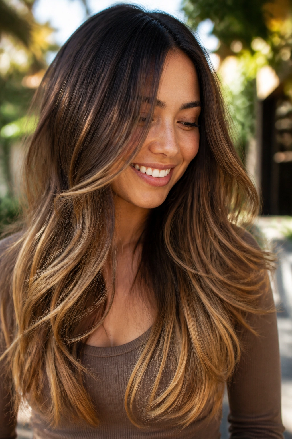 Close-up of long layered hair with a soft toffee ombré gradient