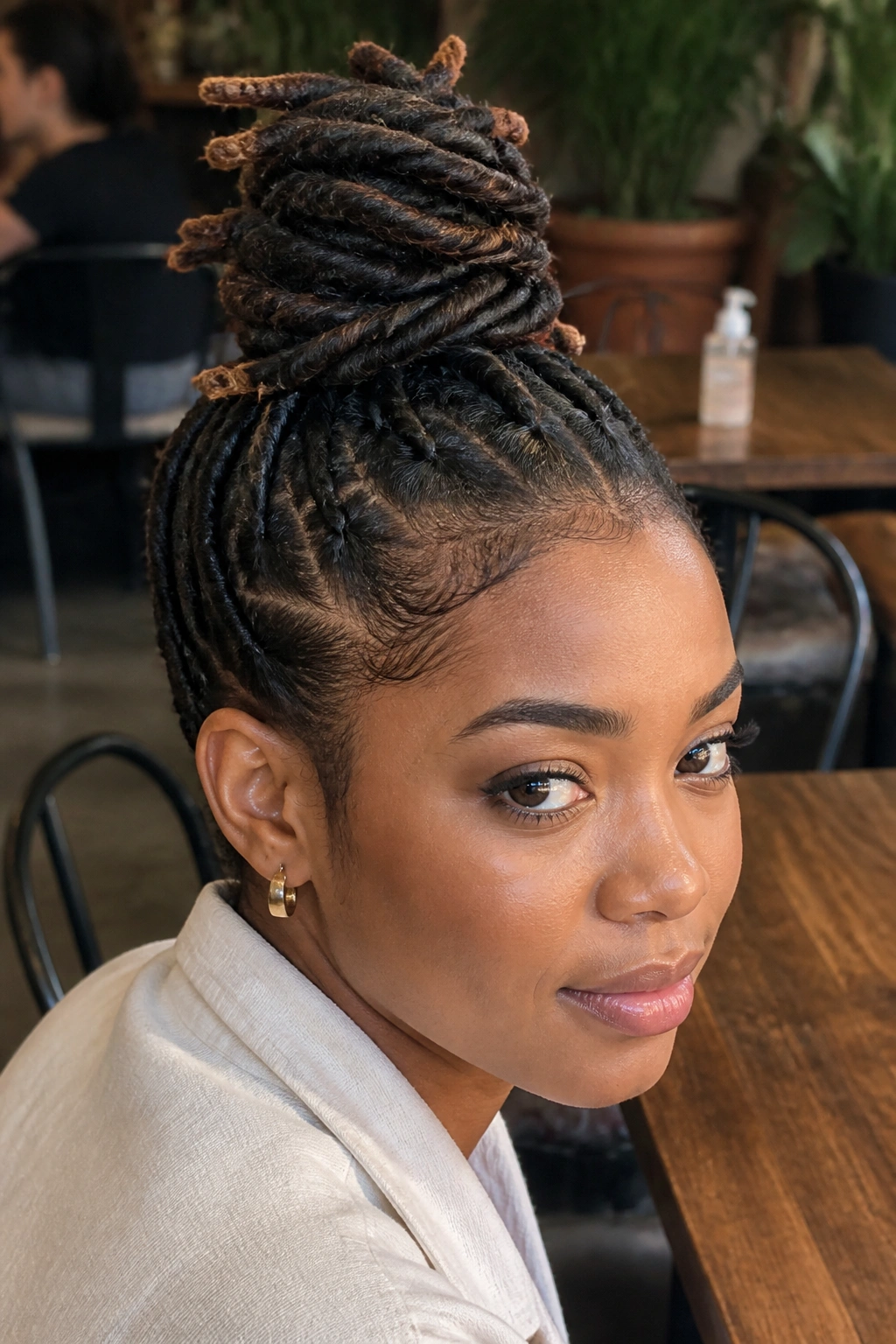 Close-up of a real person wearing a wrapped loc topknot on short locs