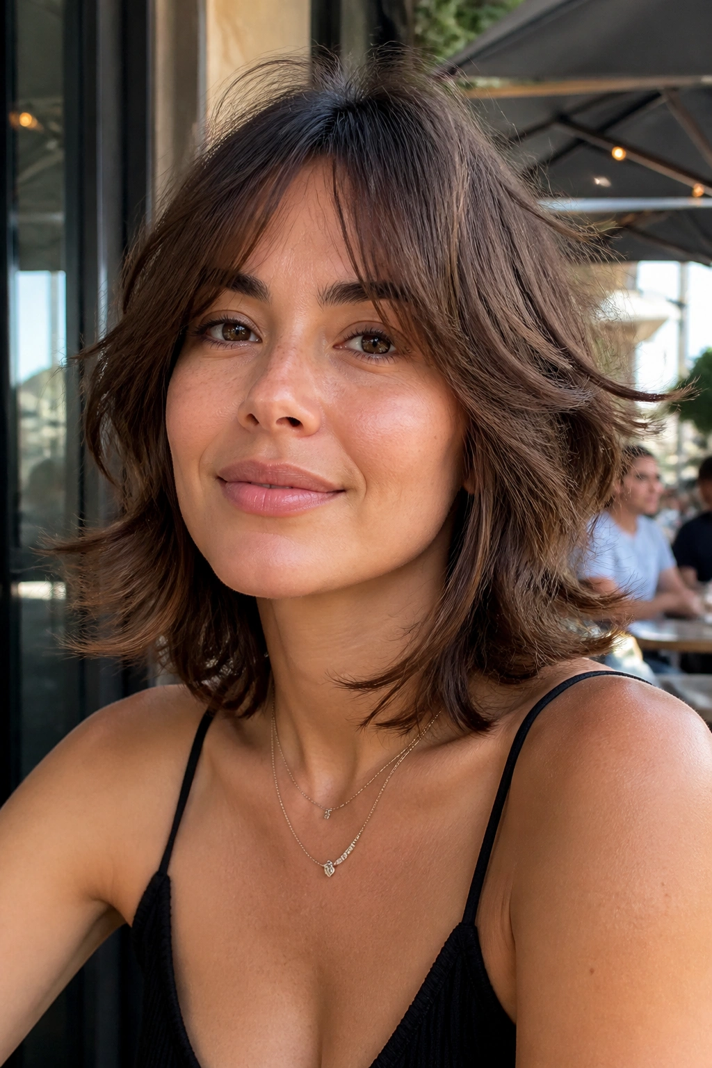 Portrait of a woman with tousled medium cut and flipped-out ends in natural light