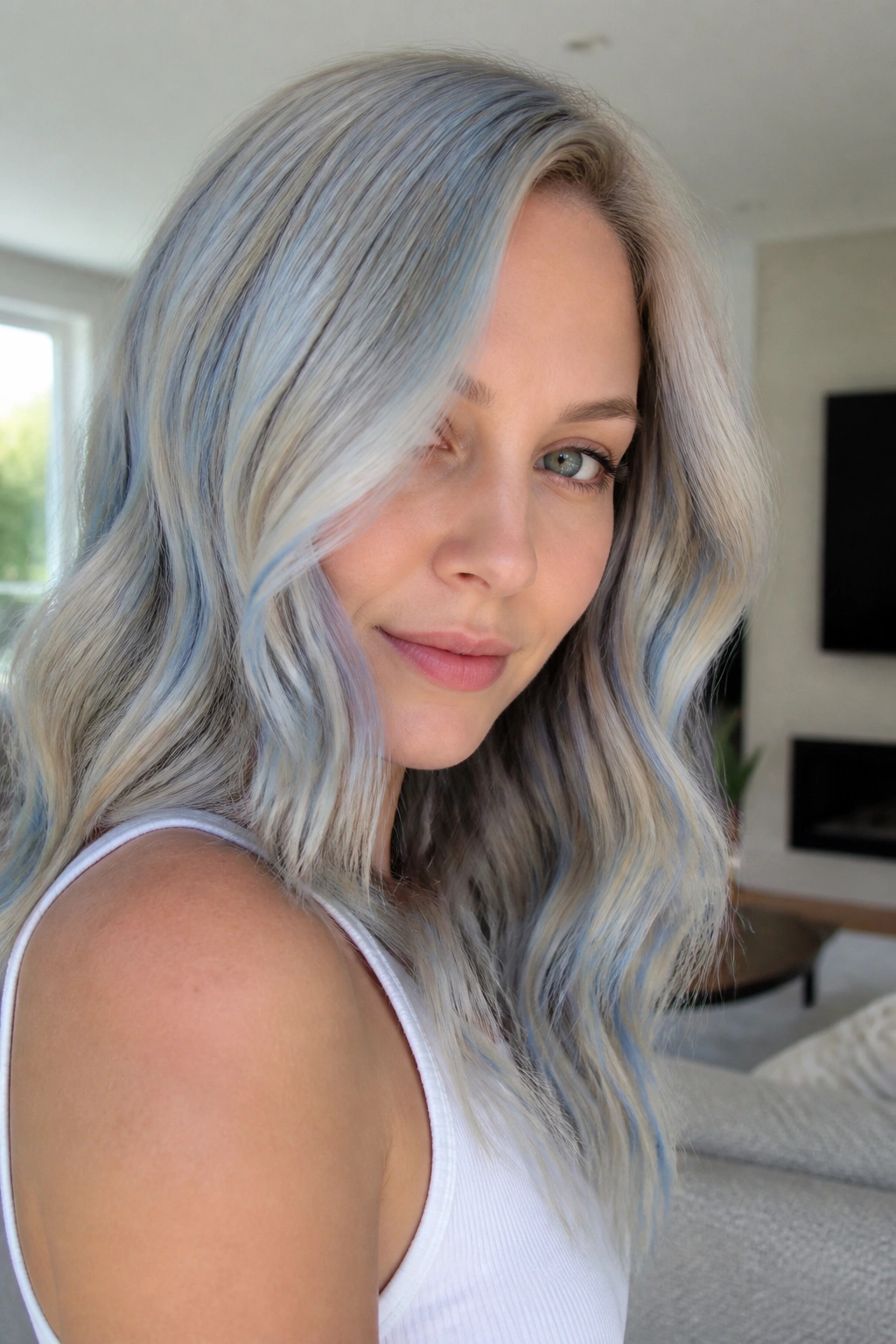 Close-up of a real woman with blonde hair enhanced by a transparent blue gloss for a cooler tone.