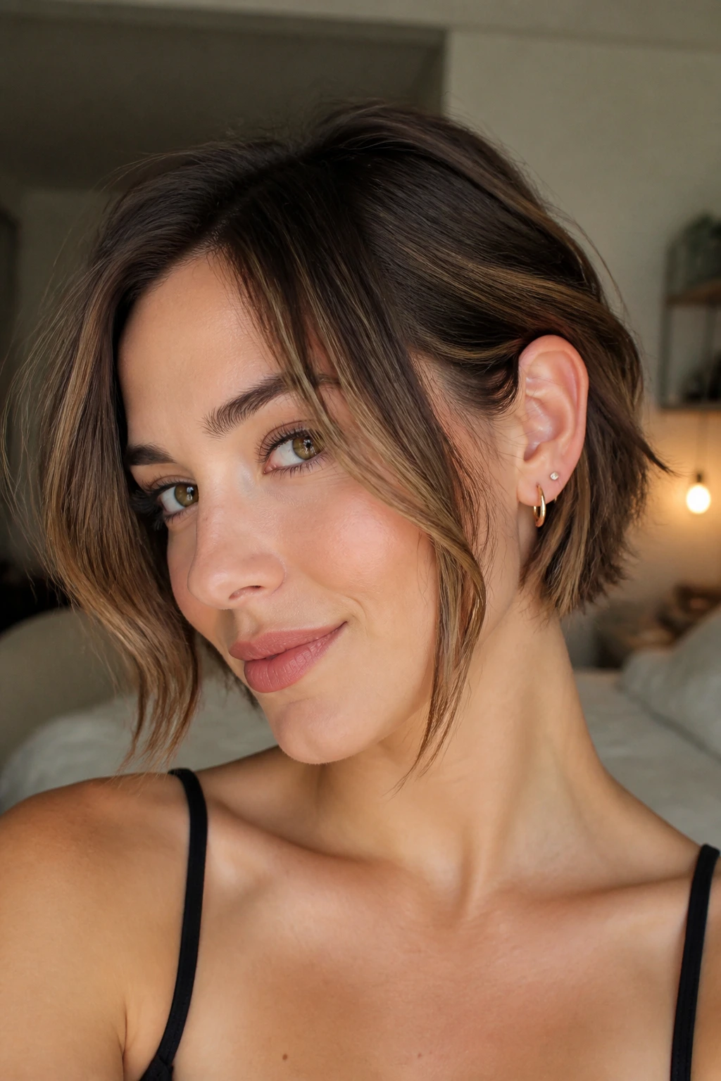 Close-up of a real woman with a tucked bob and longer face-framing pieces tucked behind the ear