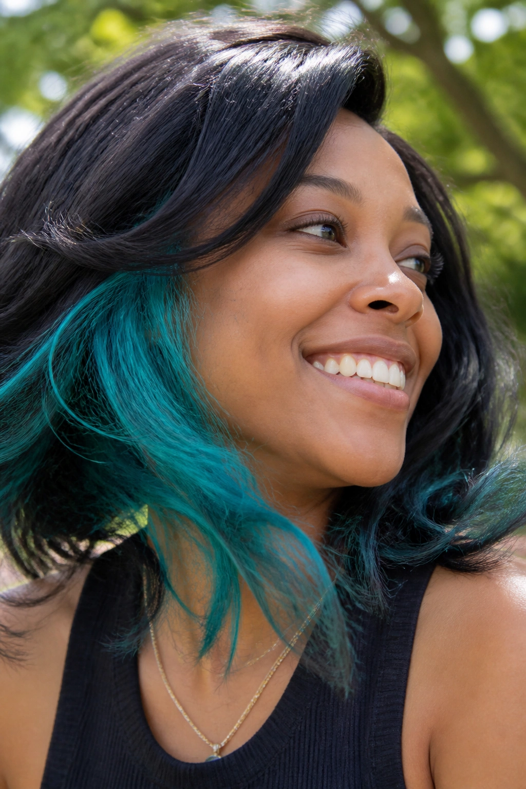 Close-up of a real person showing turquoise peekaboo underlayer in hair