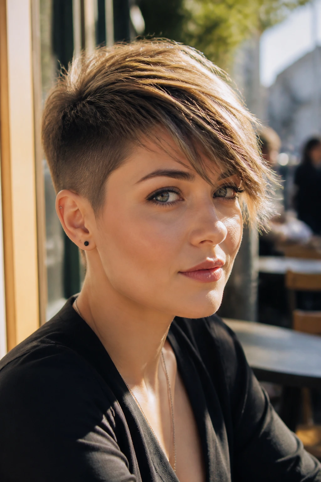 Close-up of a person with an undercut pixie and long top fringe in natural light.