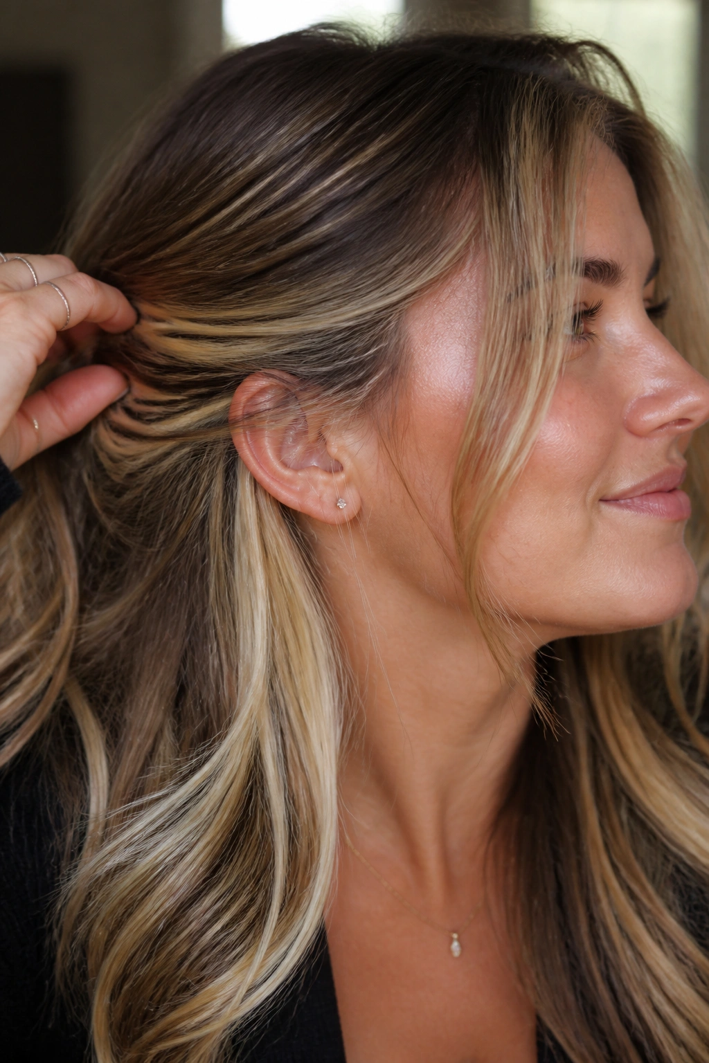 Close-up of a real woman showing hidden underlayer highlights peeking from beneath a darker top layer