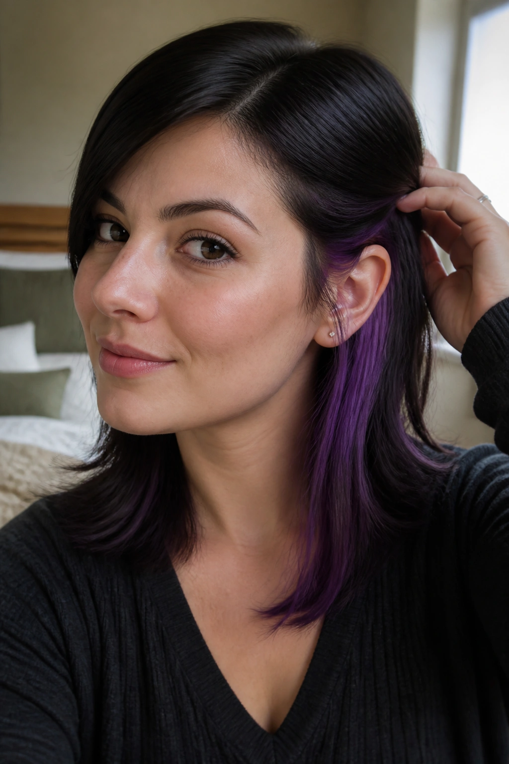 Close-up portrait of a real woman with purple underlayer peeking from beneath black hair.