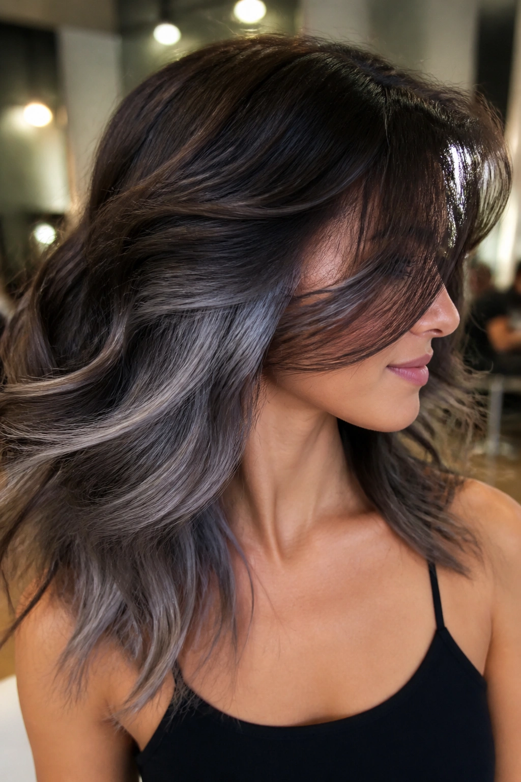Close-up of smoky silver underlights beneath brown hair on a real person.