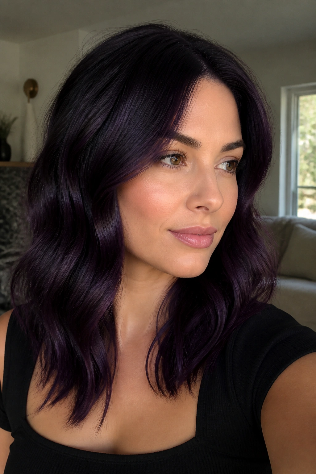Close-up portrait of a real person with violet-black hair in soft waves, flattering cool skin tones.